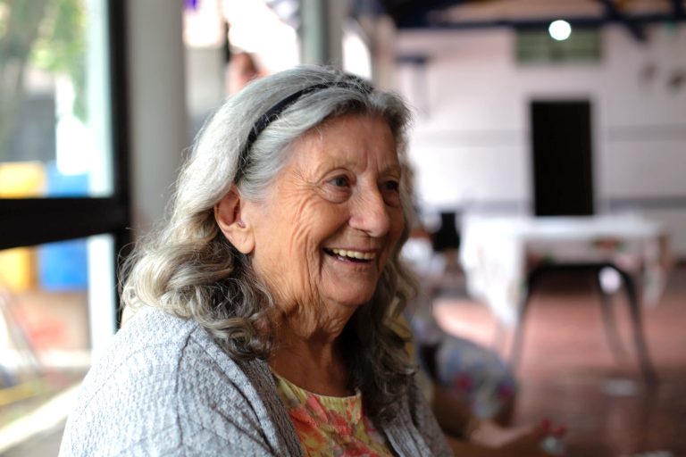 Anziana signora sorridente in un refettorio